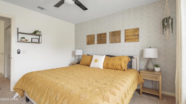 carpeted bedroom with baseboards, visible vents, wallpapered walls, and a ceiling fan