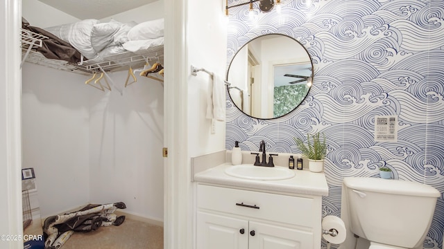 bathroom featuring toilet, vanity, and baseboards