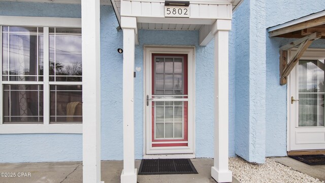 view of exterior entry featuring stucco siding