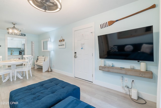 living room with light wood-type flooring and baseboards