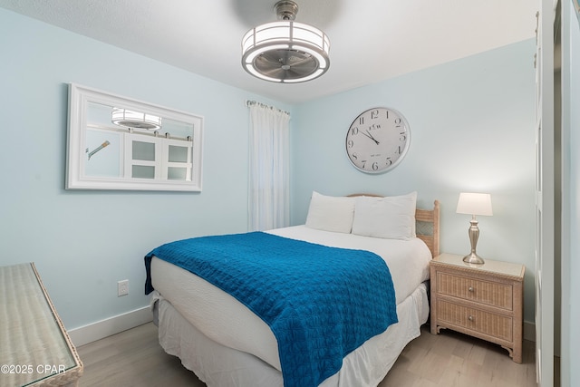 bedroom featuring wood finished floors and baseboards