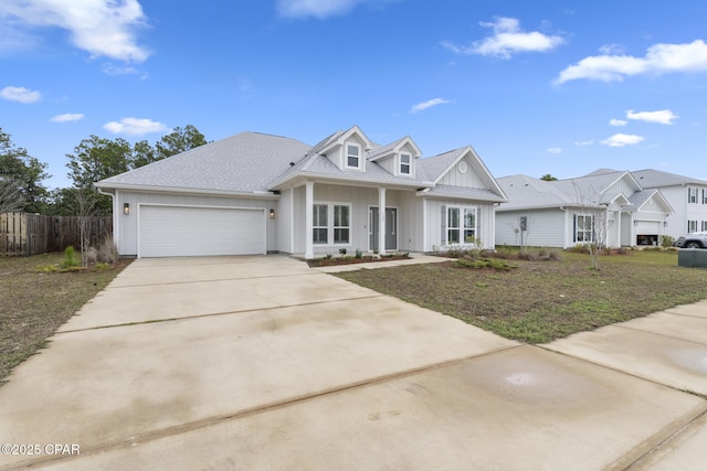 view of front facade with board and batten siding, fence, concrete driveway, roof with shingles, and an attached garage