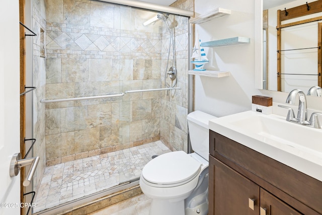 bathroom with vanity, toilet, and a stall shower