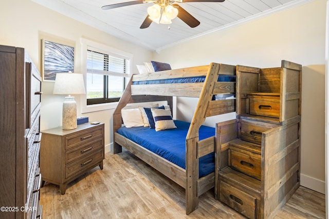 bedroom with light wood-type flooring, baseboards, a ceiling fan, and crown molding