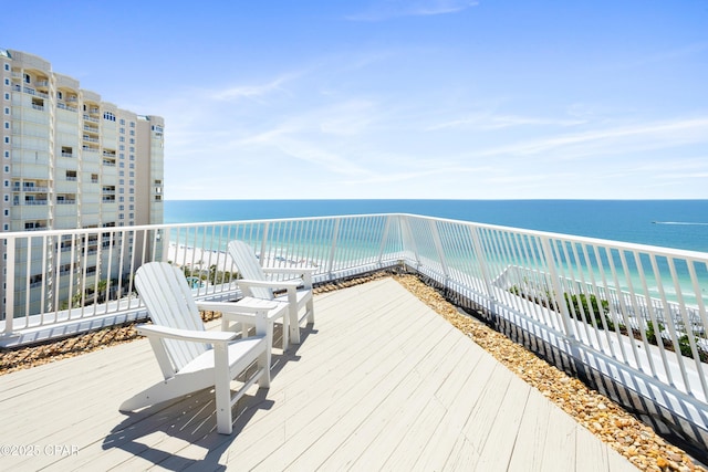 wooden deck with a beach view and a water view