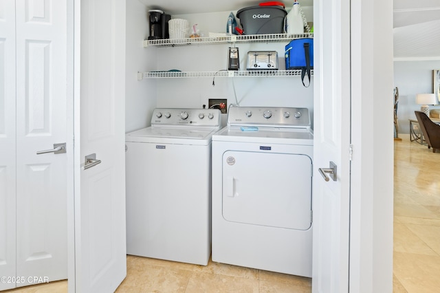 clothes washing area featuring light tile patterned floors, laundry area, and washing machine and dryer