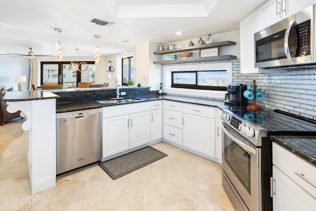 kitchen featuring a sink, decorative backsplash, a peninsula, stainless steel appliances, and open shelves