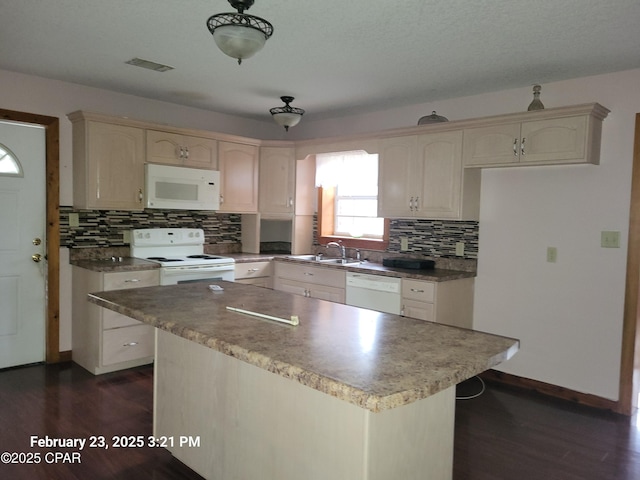 kitchen featuring backsplash, white appliances, dark wood-type flooring, and a sink