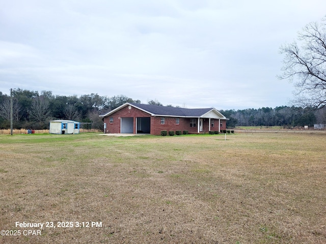 view of yard featuring an outdoor structure, a storage unit, and driveway