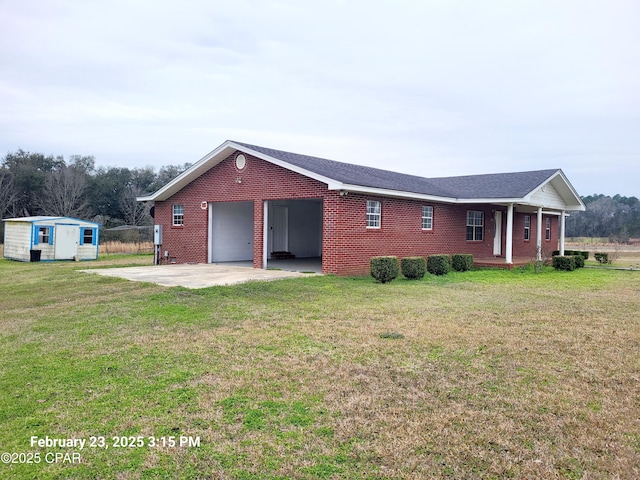 view of front of property with brick siding, concrete driveway, a front yard, an outdoor structure, and an attached garage