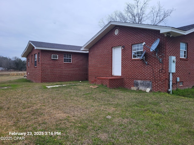 view of property exterior featuring brick siding and a yard