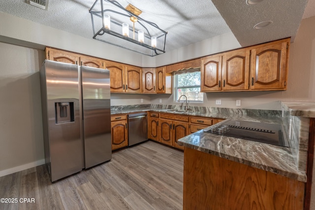 kitchen with brown cabinets, stainless steel appliances, and a sink