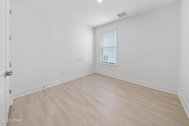 empty room with visible vents, baseboards, and light wood finished floors