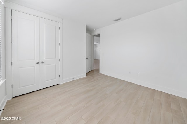 unfurnished bedroom with visible vents, light wood-style floors, a closet, and baseboards