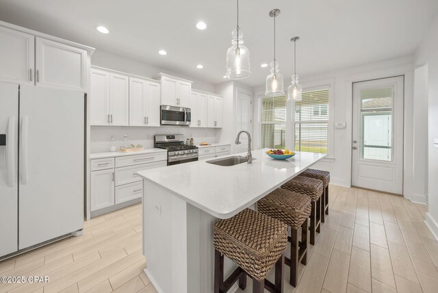 2009 Calamint St, Panama City, FL 32405 - kitchen featuring stainless steel appliances, a sink, wood finish floors, white cabinets, and recessed lighting