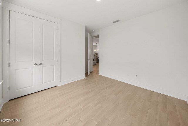 2009 Calamint St, Panama City, FL 32405 - unfurnished bedroom featuring light wood finished floors, baseboards, and a closet