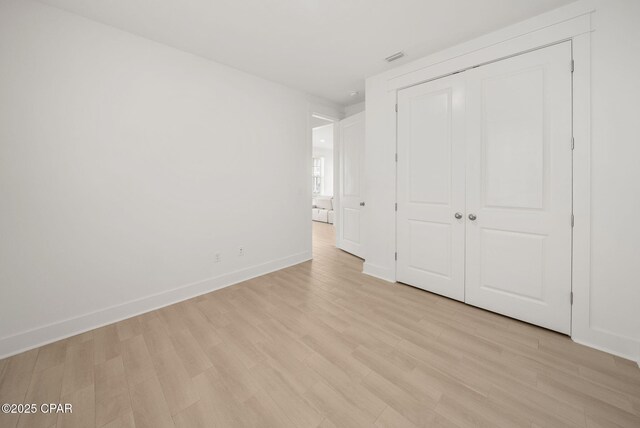 2009 Calamint St, Panama City, FL 32405 - unfurnished bedroom featuring light wood finished floors, baseboards, and a closet