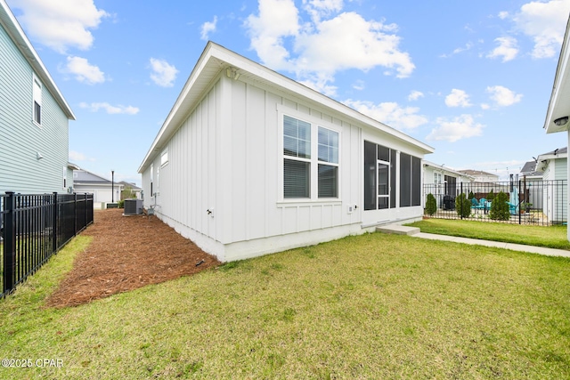 rear view of house featuring central air condition unit, a yard, a fenced backyard, and board and batten siding