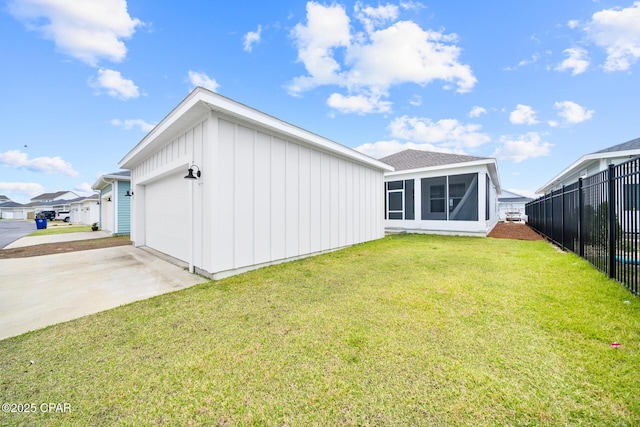 back of property with board and batten siding, fence, a yard, a garage, and driveway