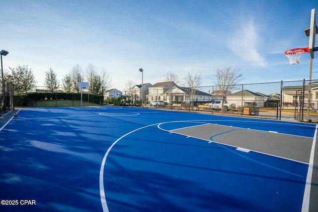 view of sport court featuring community basketball court, fence, and a residential view