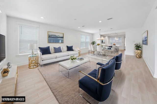 living room featuring visible vents, wood finished floors, recessed lighting, an inviting chandelier, and baseboards