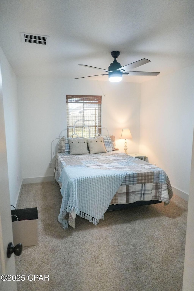 carpeted bedroom featuring visible vents, baseboards, and a ceiling fan