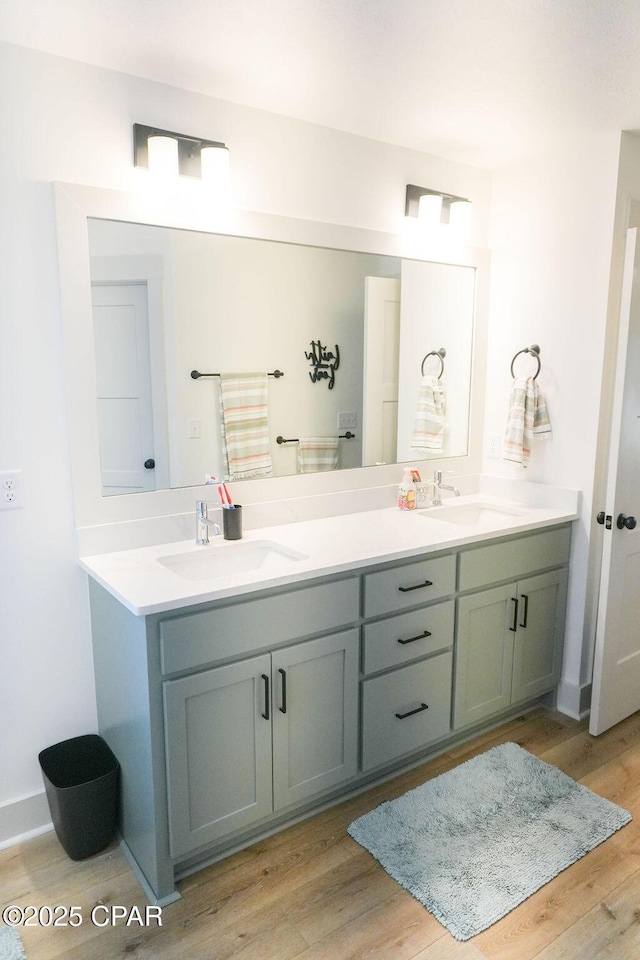 full bath featuring a sink, wood finished floors, and double vanity