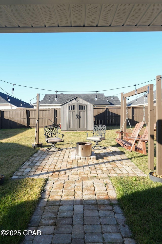 view of patio featuring an outdoor fire pit, a storage shed, a fenced backyard, and an outdoor structure