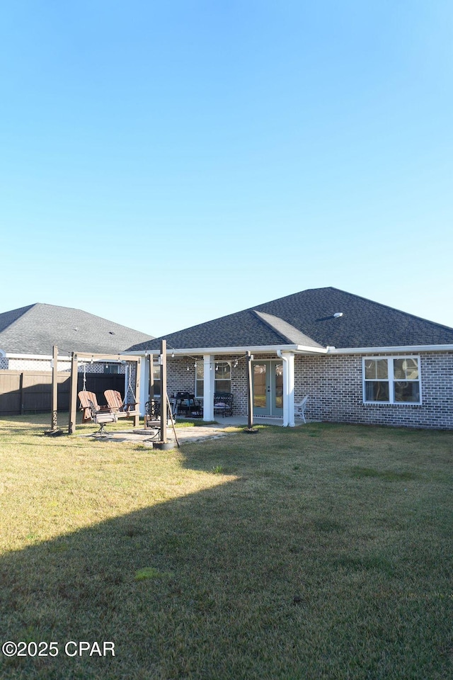 back of property featuring a patio area, brick siding, a yard, and fence