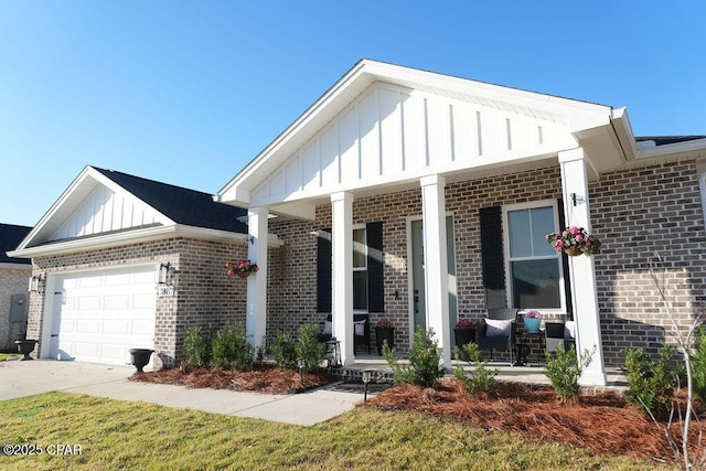 view of front of property featuring driveway, a porch, board and batten siding, a garage, and brick siding