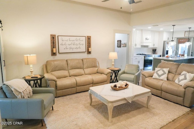 living room with light wood finished floors and a ceiling fan