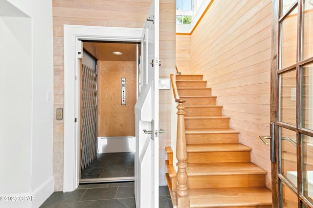 239 Sand Oaks Cir, Santa Rosa Beach, FL 32459 - stairs featuring tile patterned flooring, a skylight, elevator, and wood walls
