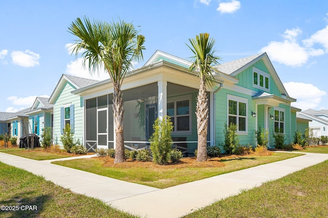 view of front of house with a front yard and a sunroom