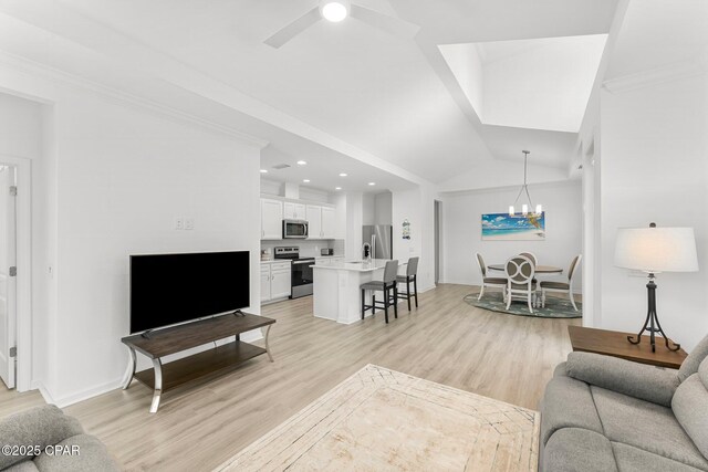 living room with baseboards, light wood-style floors, ornamental molding, and vaulted ceiling