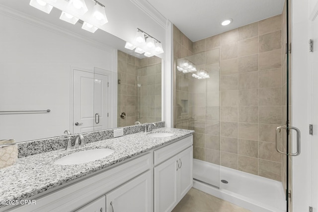 bathroom with a shower stall, ornamental molding, and a sink