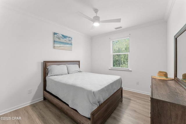 bedroom featuring crown molding, baseboards, visible vents, and light wood-type flooring