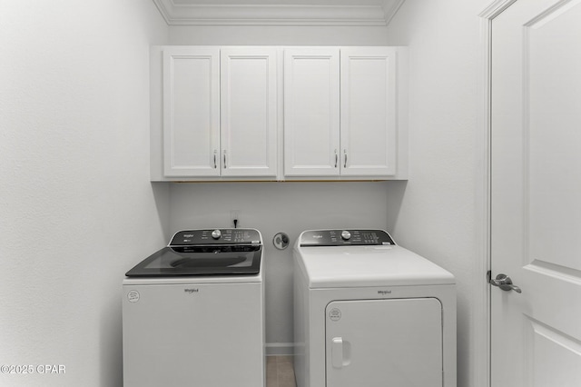 washroom featuring washing machine and clothes dryer, cabinet space, and ornamental molding