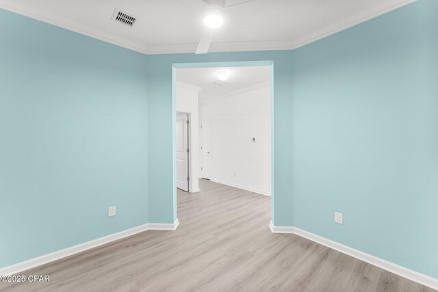 unfurnished room with visible vents, baseboards, ornamental molding, and light wood finished floors