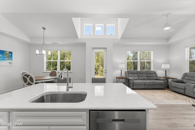 kitchen featuring a sink, light stone counters, and vaulted ceiling