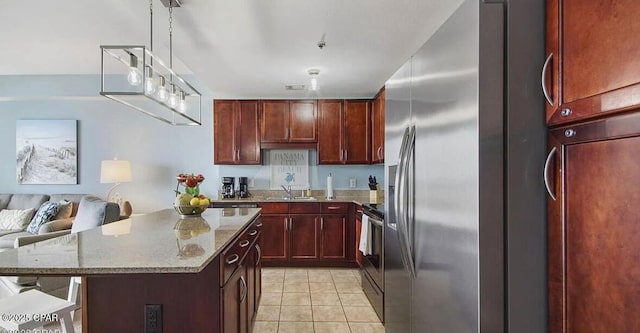 kitchen featuring a sink, open floor plan, stainless steel appliances, reddish brown cabinets, and light tile patterned floors