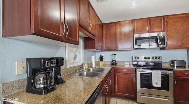 kitchen with visible vents, light stone countertops, light tile patterned floors, appliances with stainless steel finishes, and a sink