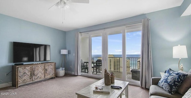 carpeted living room with baseboards and ceiling fan