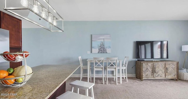 dining area featuring baseboards and carpet