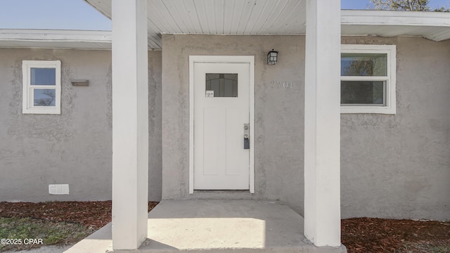 property entrance featuring crawl space and stucco siding