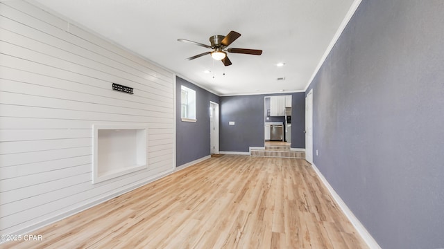 unfurnished living room with baseboards, light wood-type flooring, ceiling fan, and ornamental molding