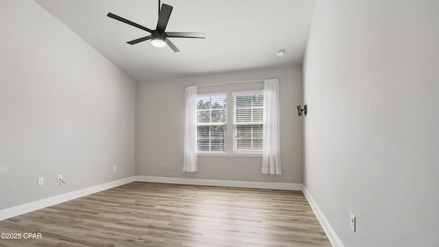 empty room featuring baseboards, wood finished floors, a ceiling fan, and vaulted ceiling