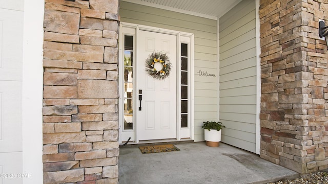 doorway to property with stone siding and a porch