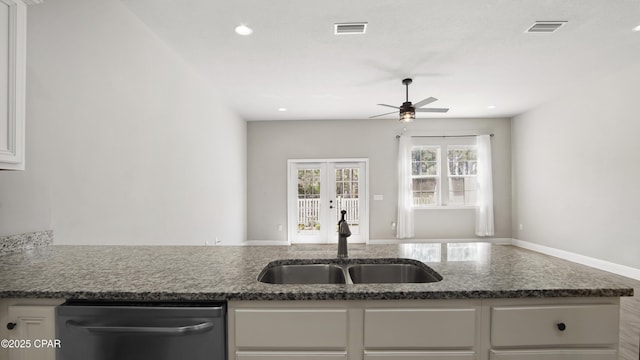 kitchen featuring dishwasher, white cabinets, visible vents, and a sink