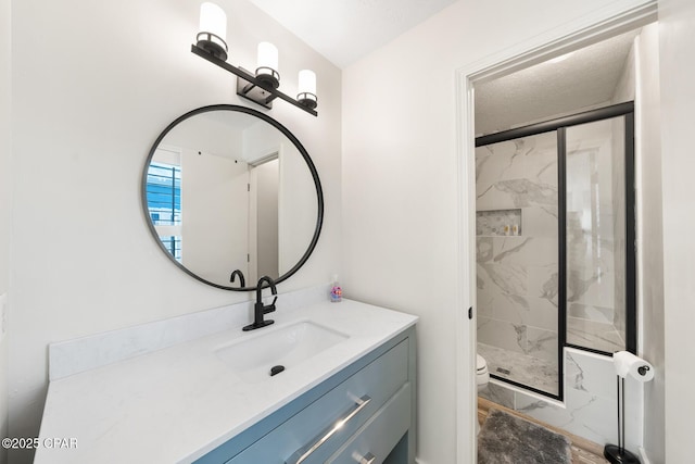 full bath with a marble finish shower, toilet, marble finish floor, and vanity