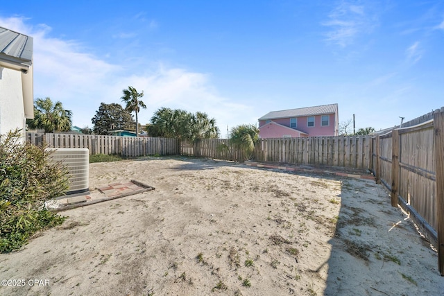 view of yard with central air condition unit and a fenced backyard